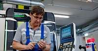 Ein Mann arbeitet mit Werkzeug in einer modernen Maschinenwerkstatt.