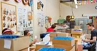 Freiwillige sortieren und verpacken Materialien in einem Arbeitsraum.