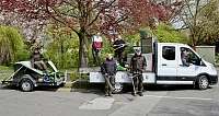 Ein Team von Gärtnern steht neben einem Fahrzeug und Equipment.