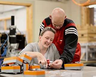 Eine Frau und ein Mann arbeiten gemeinsam an einem technischen Projekt.