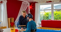 Eine Frau interagiert mit einem Jungen in einem Therapieraum.