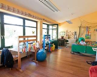 Ein Spielzimmer mit Spielgeräten und einem Ballpool.