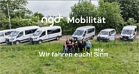 Eine Gruppe von Menschen steht vor mehreren weißen Transportern.