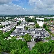 Blick auf ein Industriegebiet mit vielen Bäumen und Gebäuden.